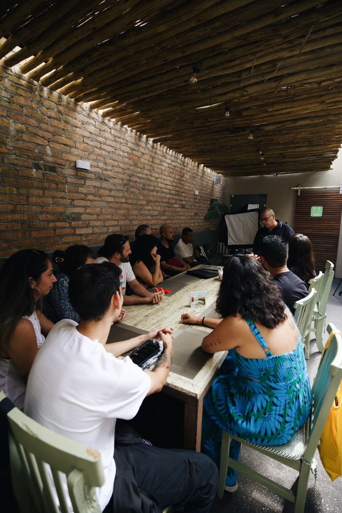 A diverse group of adults attentively participates in an indoor educational workshop.